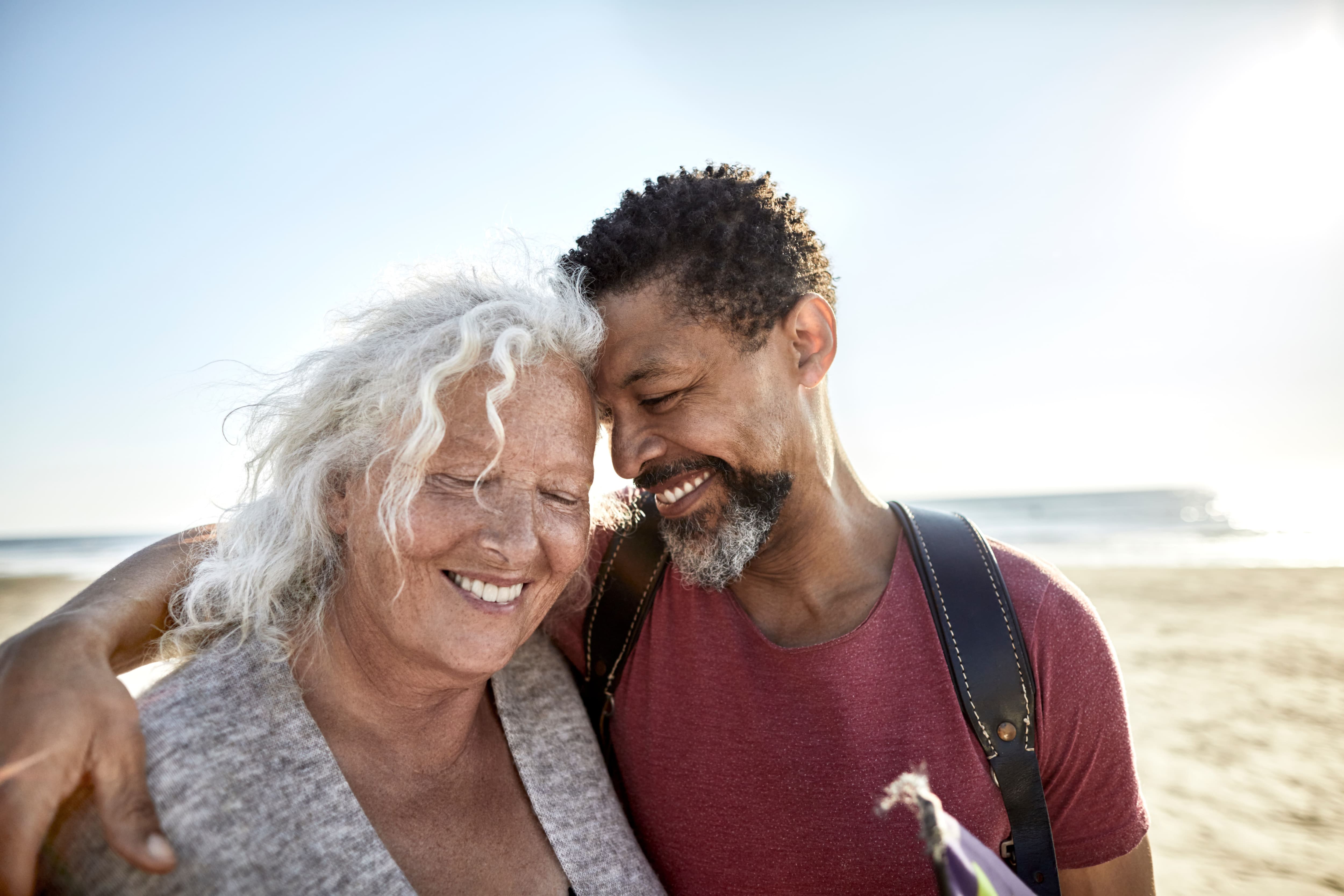 Senior woman and son walking on the beach.